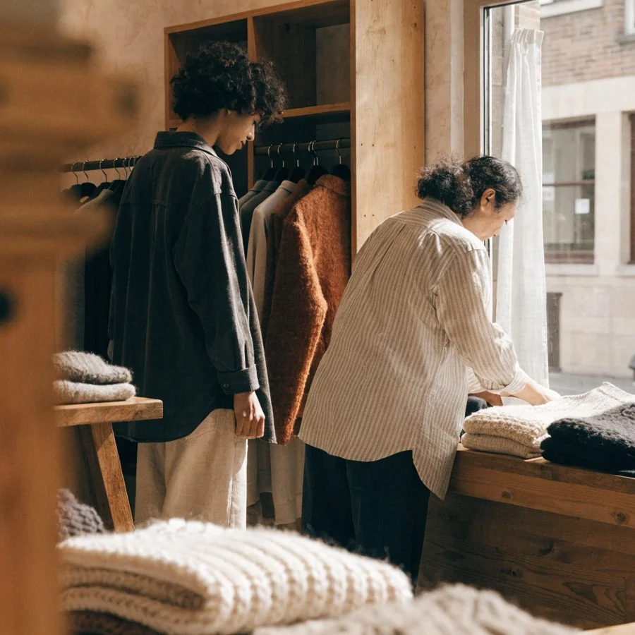 Une cliente parcourt les portants d’une boutique de prêt-à-porter indépendante.